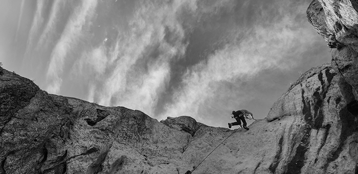 Wspinający się człowiek wiszący na linie Wspinający się człowiek wiszący na linie